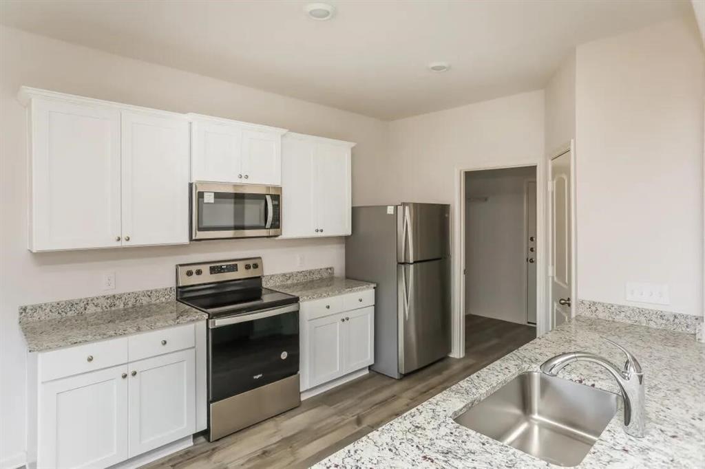 a kitchen with stainless steel appliances granite countertop a refrigerator sink and stove