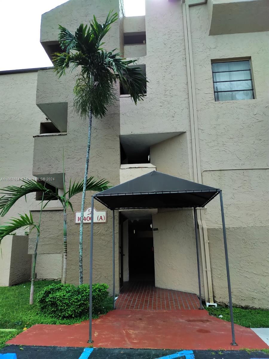 a front view of a house with garage and plants