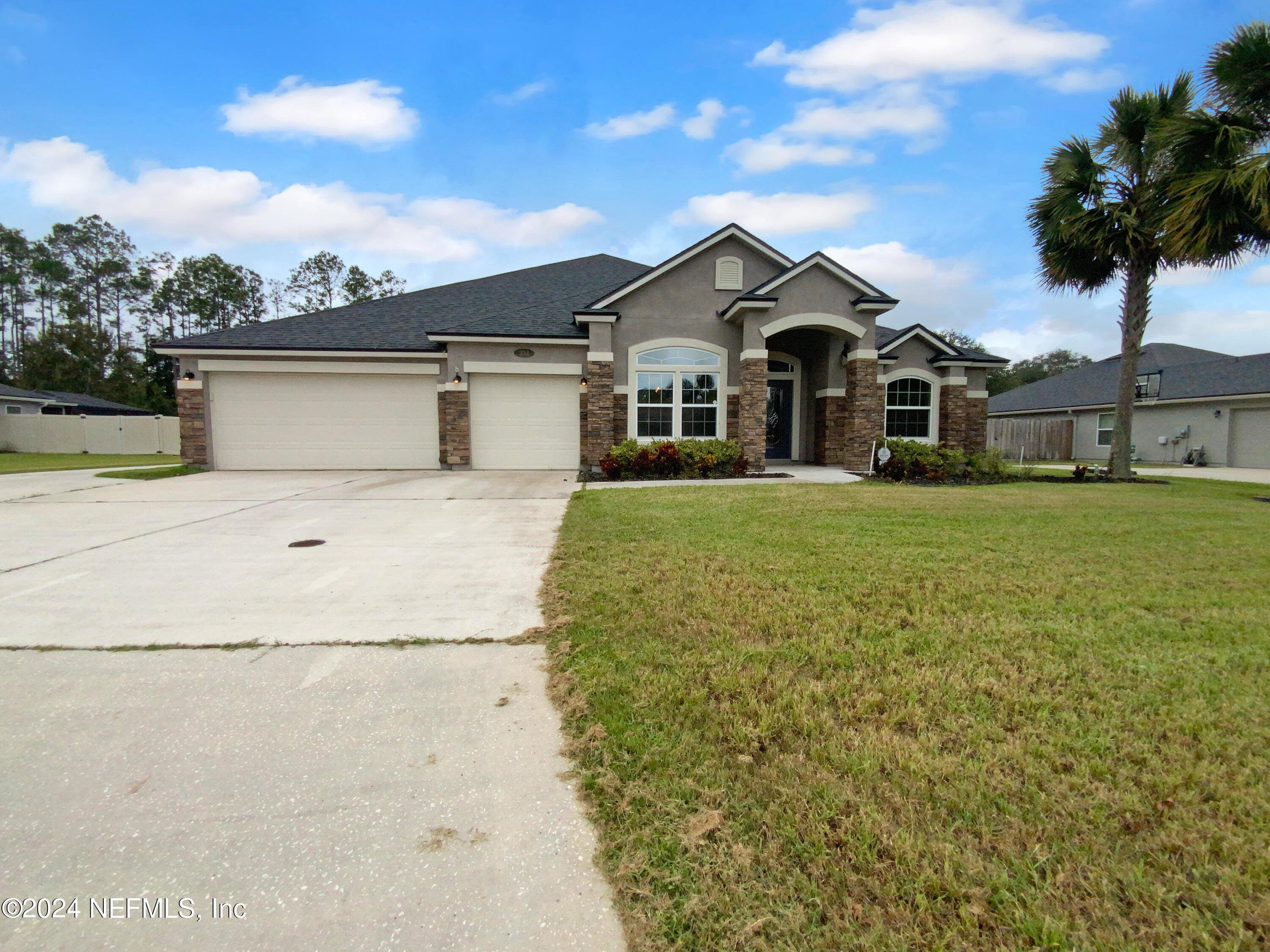 a front view of a house with yard and garage