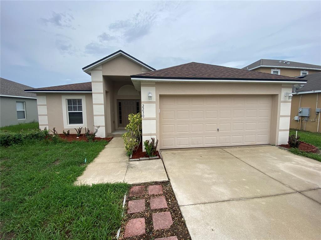 a front view of a house with a yard and garage