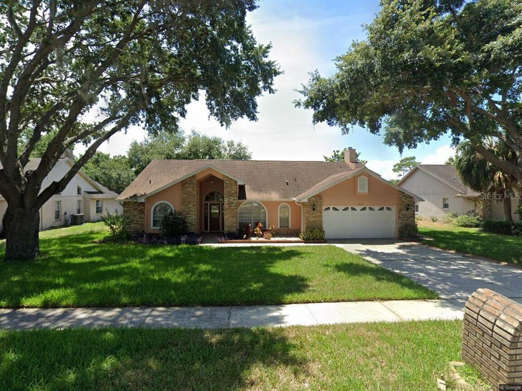 a front view of a house with yard and green space