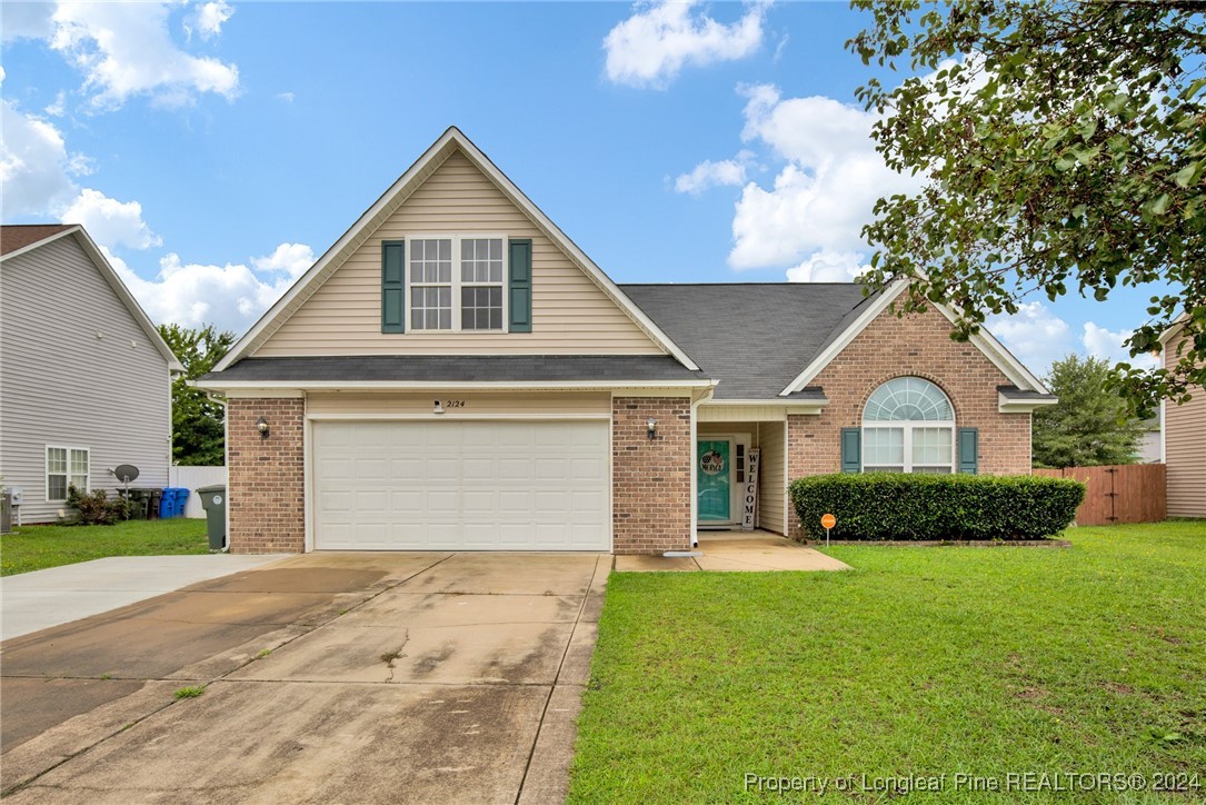 a front view of a house with a yard and garage