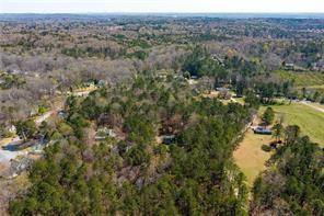 an aerial view of residential house with outdoor space and trees all around