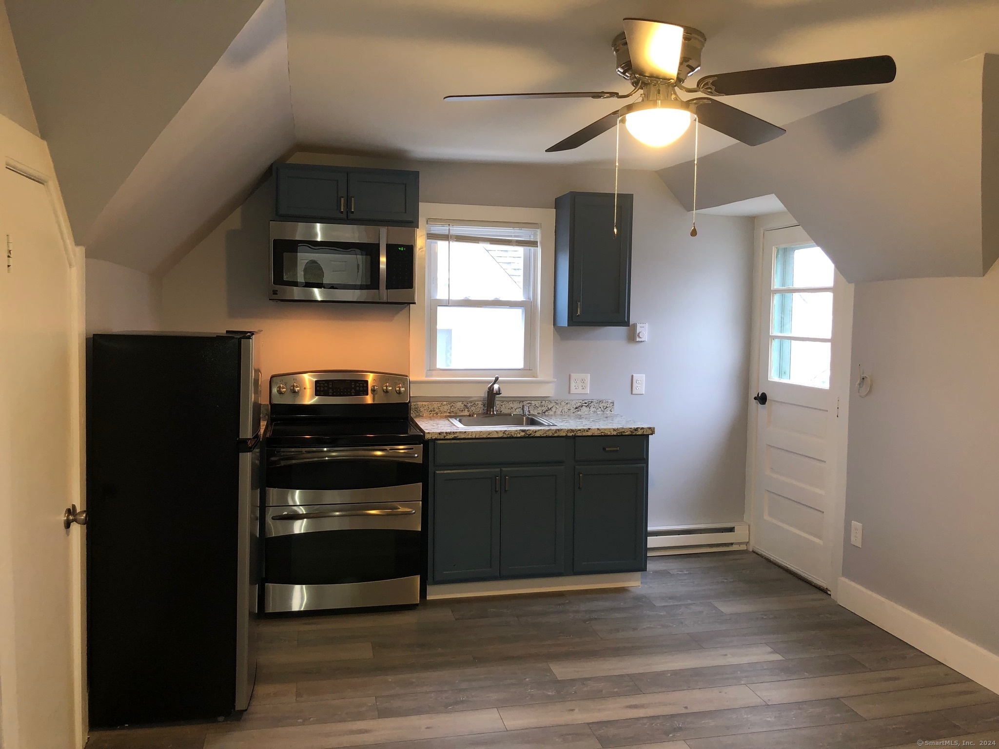 a kitchen with stainless steel appliances kitchen island granite countertop a refrigerator and a sink