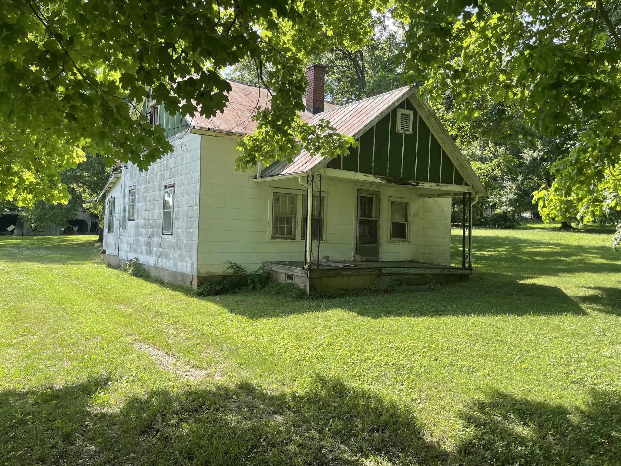 a view of a house with backyard and a tree