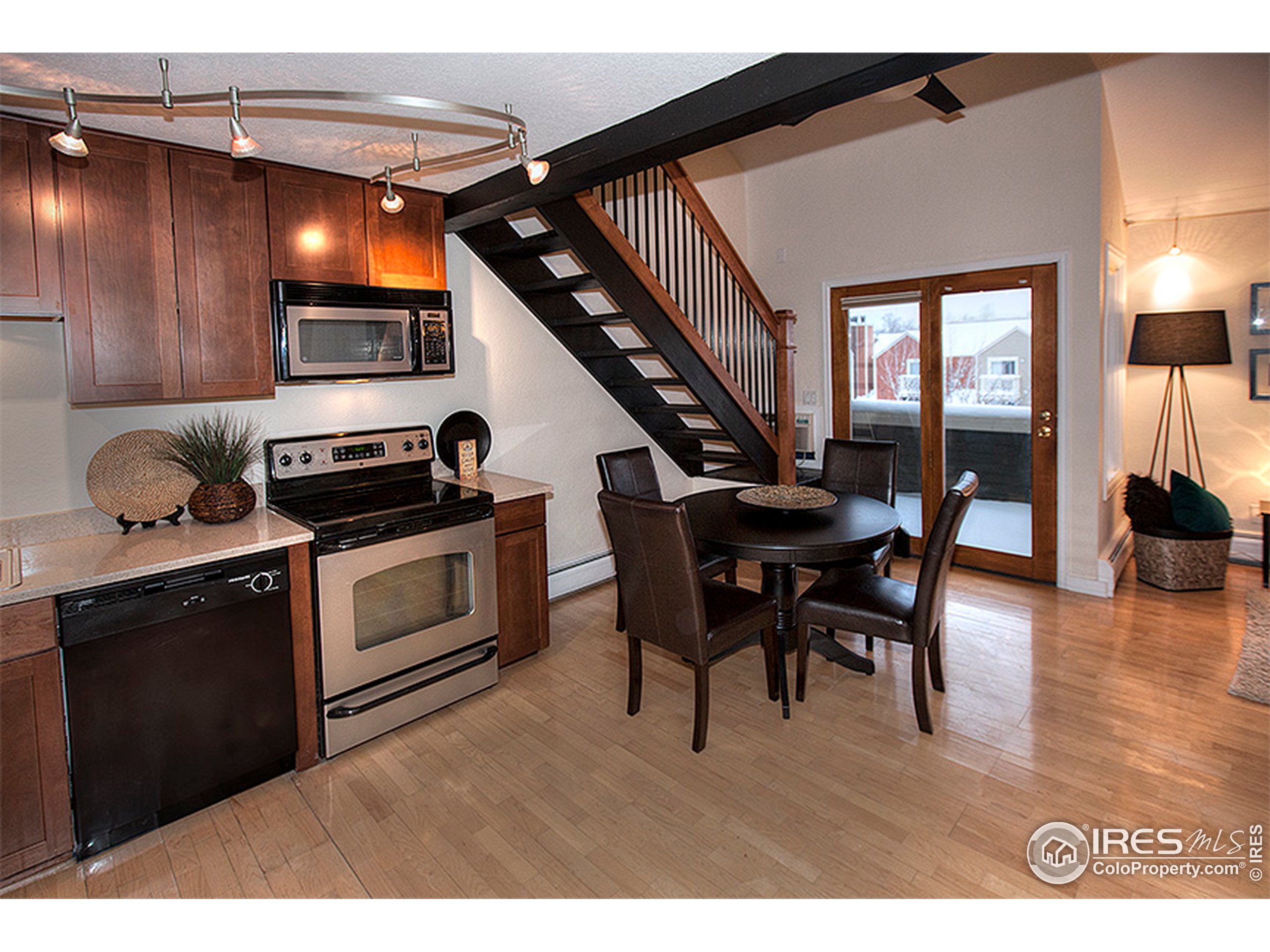 a kitchen with stainless steel appliances kitchen island granite countertop a table chairs and a refrigerator