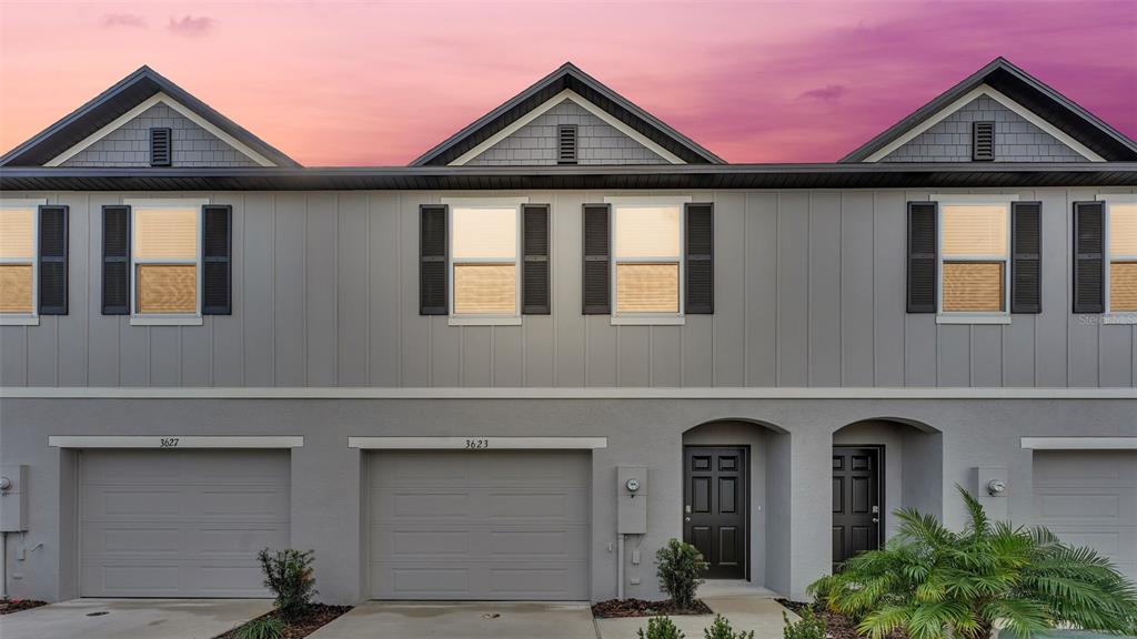 a front view of a house with yard and parking