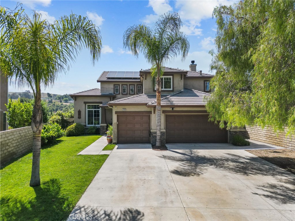 a view of a house with a yard and palm trees