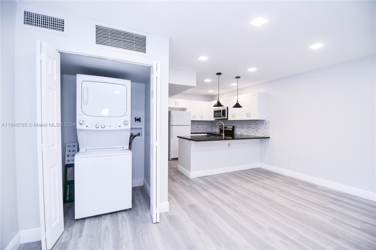 a kitchen with a refrigerator and white cabinets