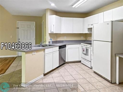 a kitchen with white cabinets and white appliances