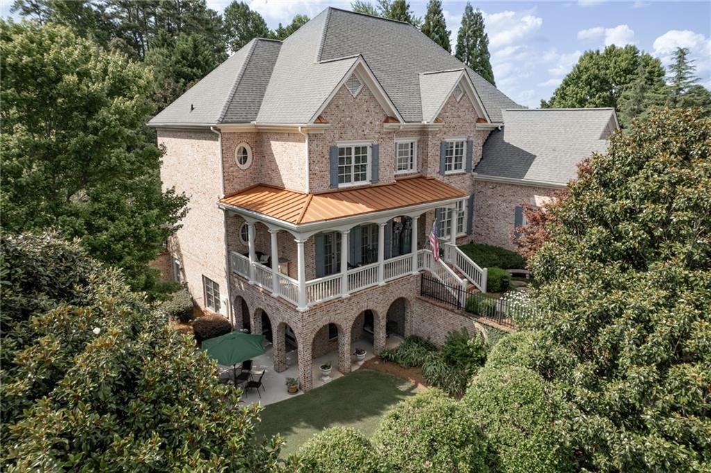 an aerial view of a house with a big yard and large trees