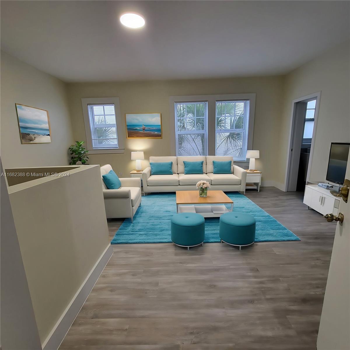 a living room with furniture wooden floor and a large window