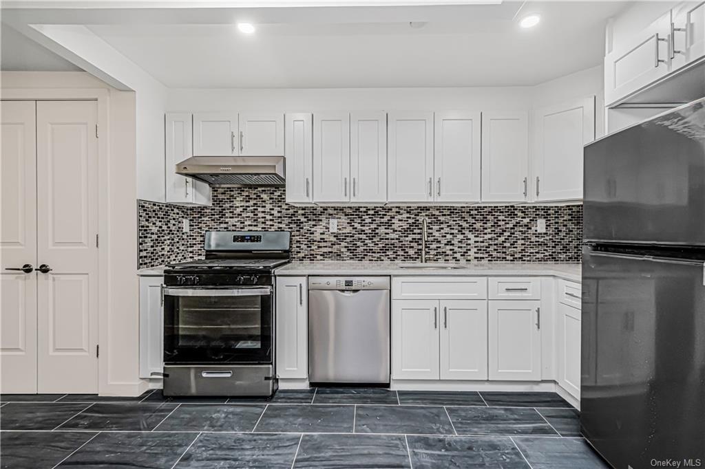 a kitchen with stainless steel appliances a stove a sink and a refrigerator