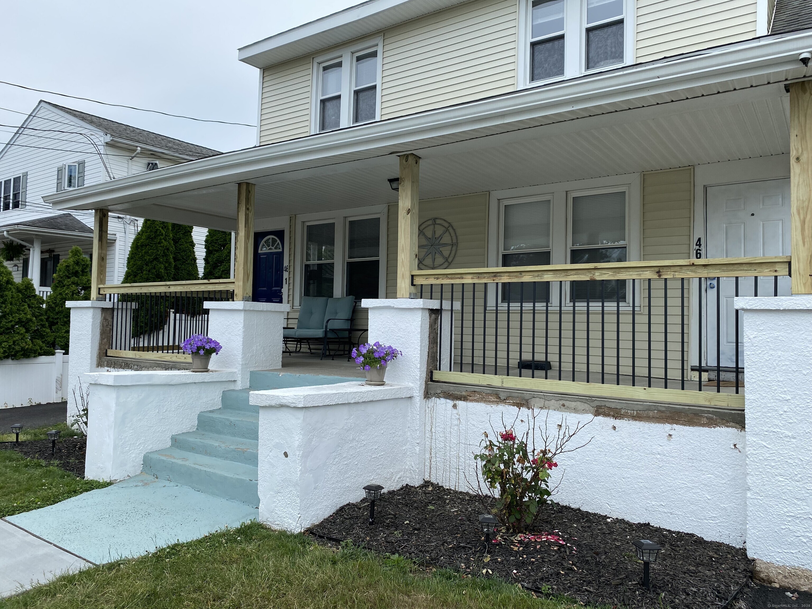 a view of a house with a porch and furniture