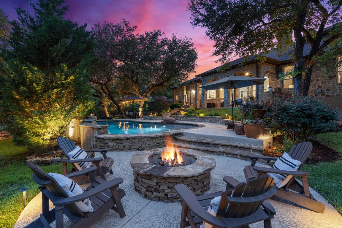 a patio with sofas fire pit table and chairs