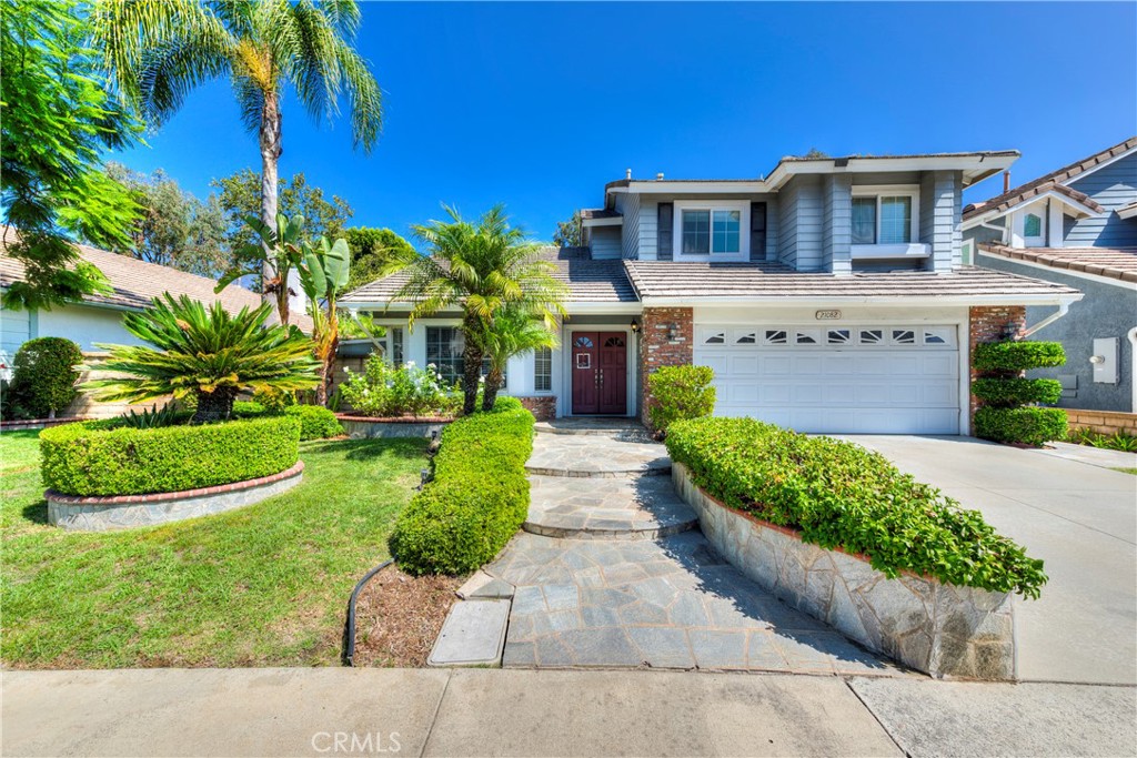 a front view of a house with a yard and potted plants