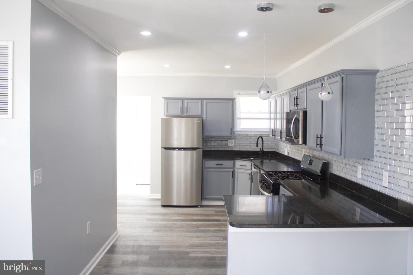 a kitchen with granite countertop a sink a refrigerator and a stove