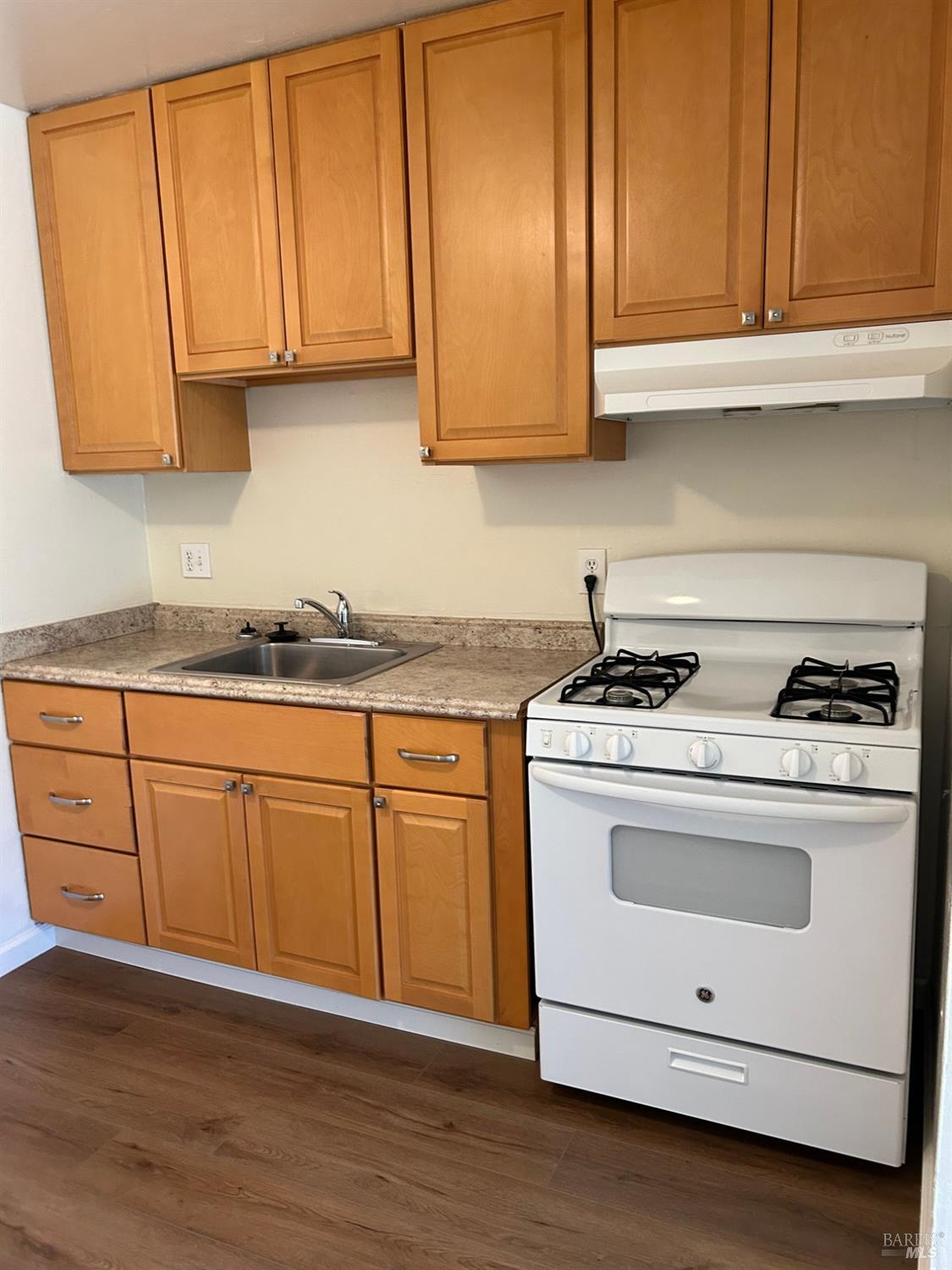 a kitchen with granite countertop cabinets stainless steel appliances and sink