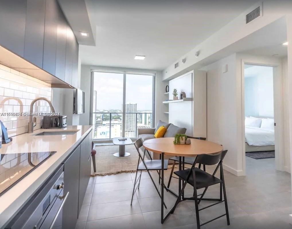 a kitchen with a table chairs sink and cabinets