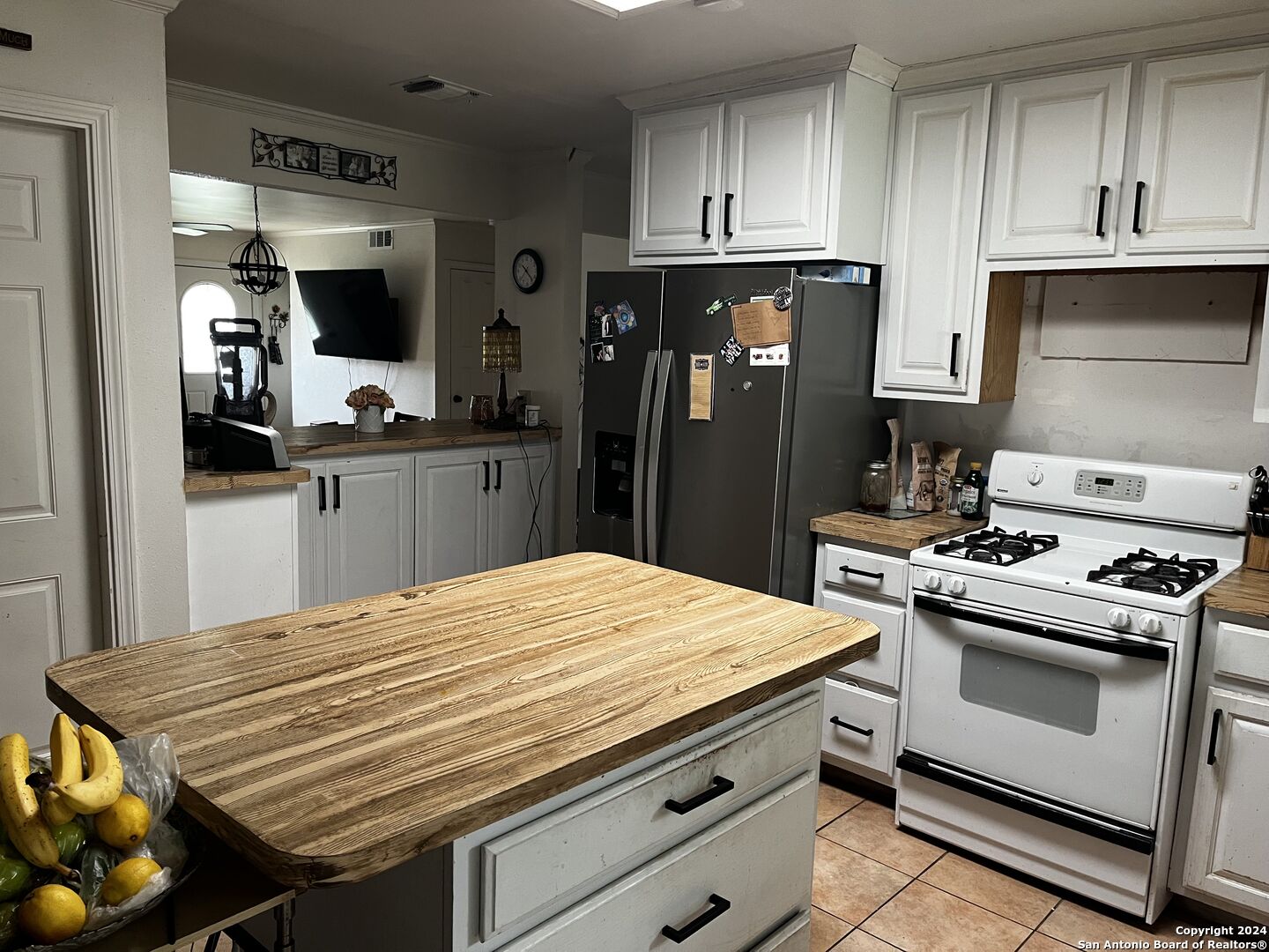 a kitchen with a stove a refrigerator and cabinets