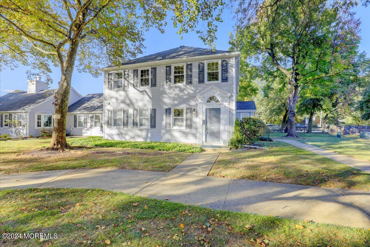 a front view of a house with yard and green space