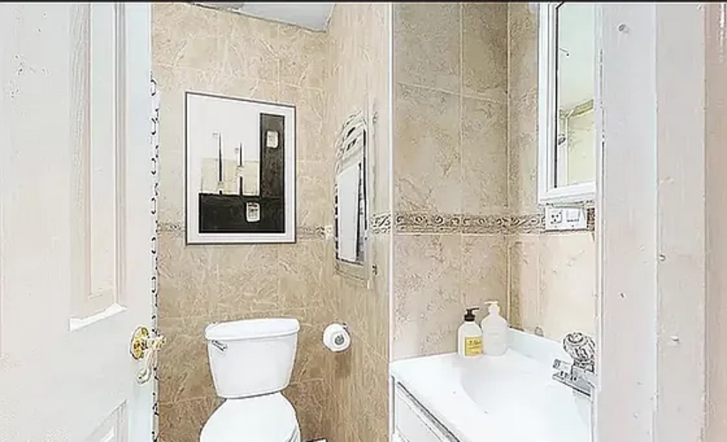 a bathroom with a toilet sink and mirror