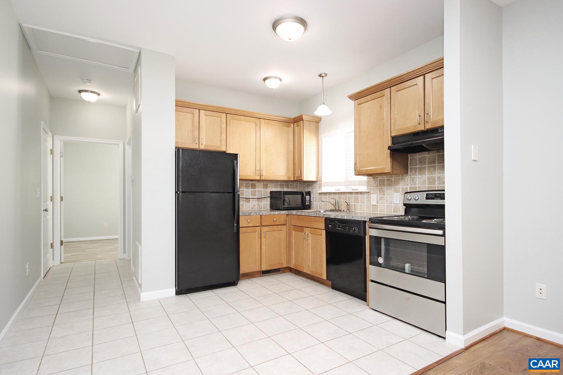 a kitchen with a refrigerator a stove top oven and cabinets