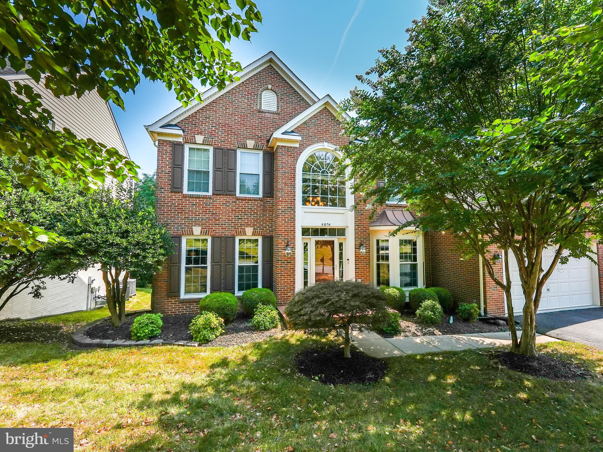 a front view of a house with yard and green space