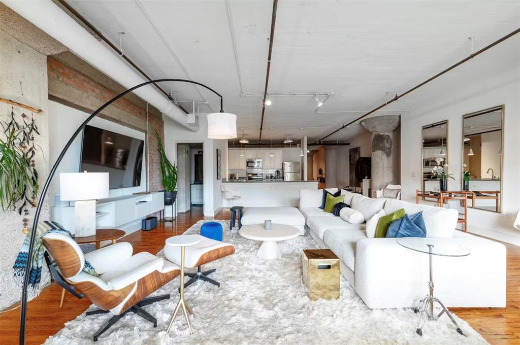 a living room with furniture a flat screen tv and kitchen view