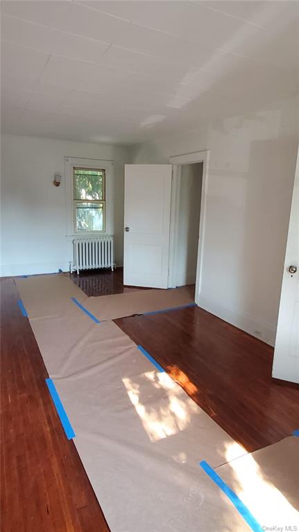 a view of a room with wooden floor and a window