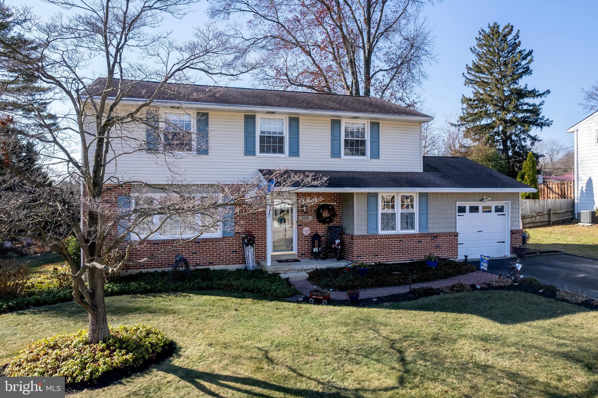 a front view of a house with a yard and a fountain