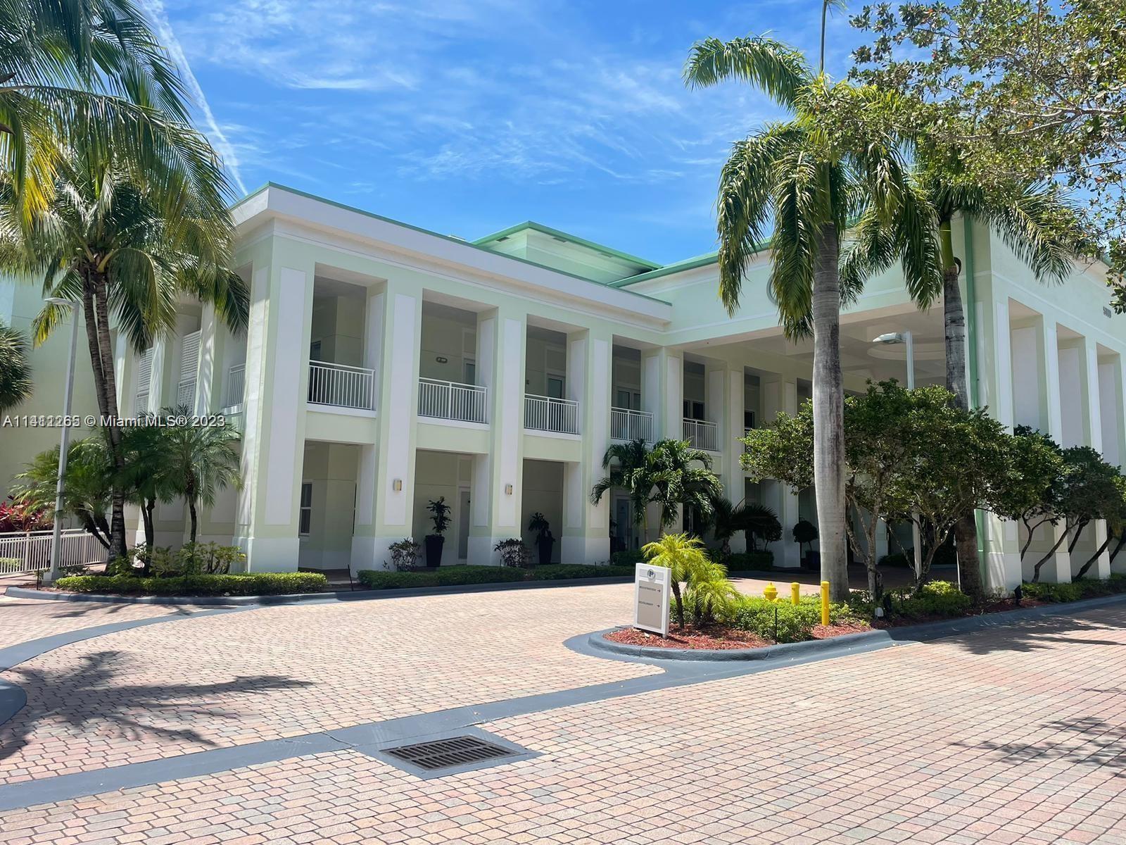 a view of a house with a yard and palm trees