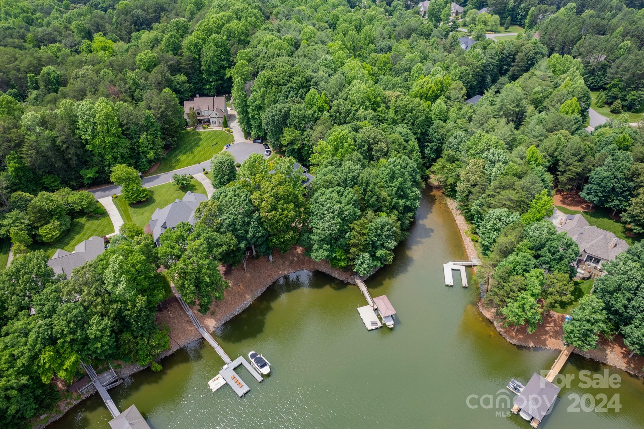 an aerial view of a house with a yard and lake view