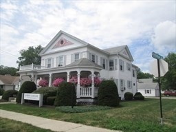 a front view of a house with a garden and plants