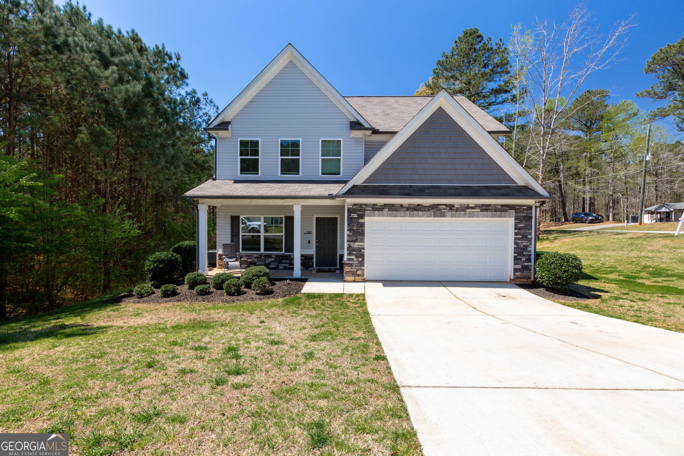 a front view of a house with a yard and seating space