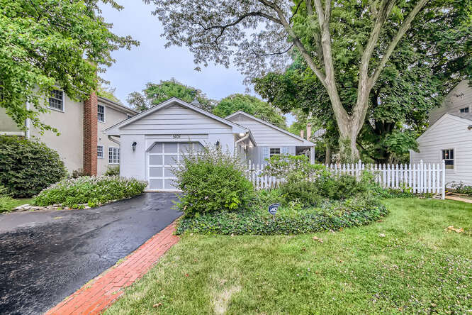 a front view of a house with a yard and trees