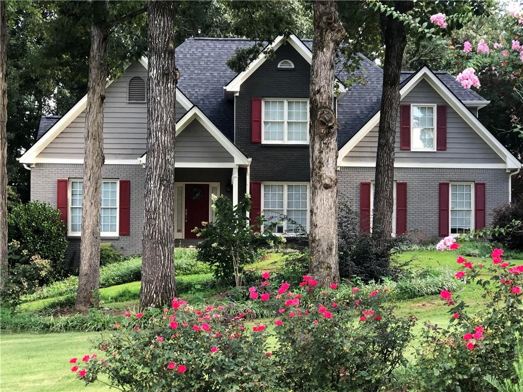 a front view of a house with a yard and fountain