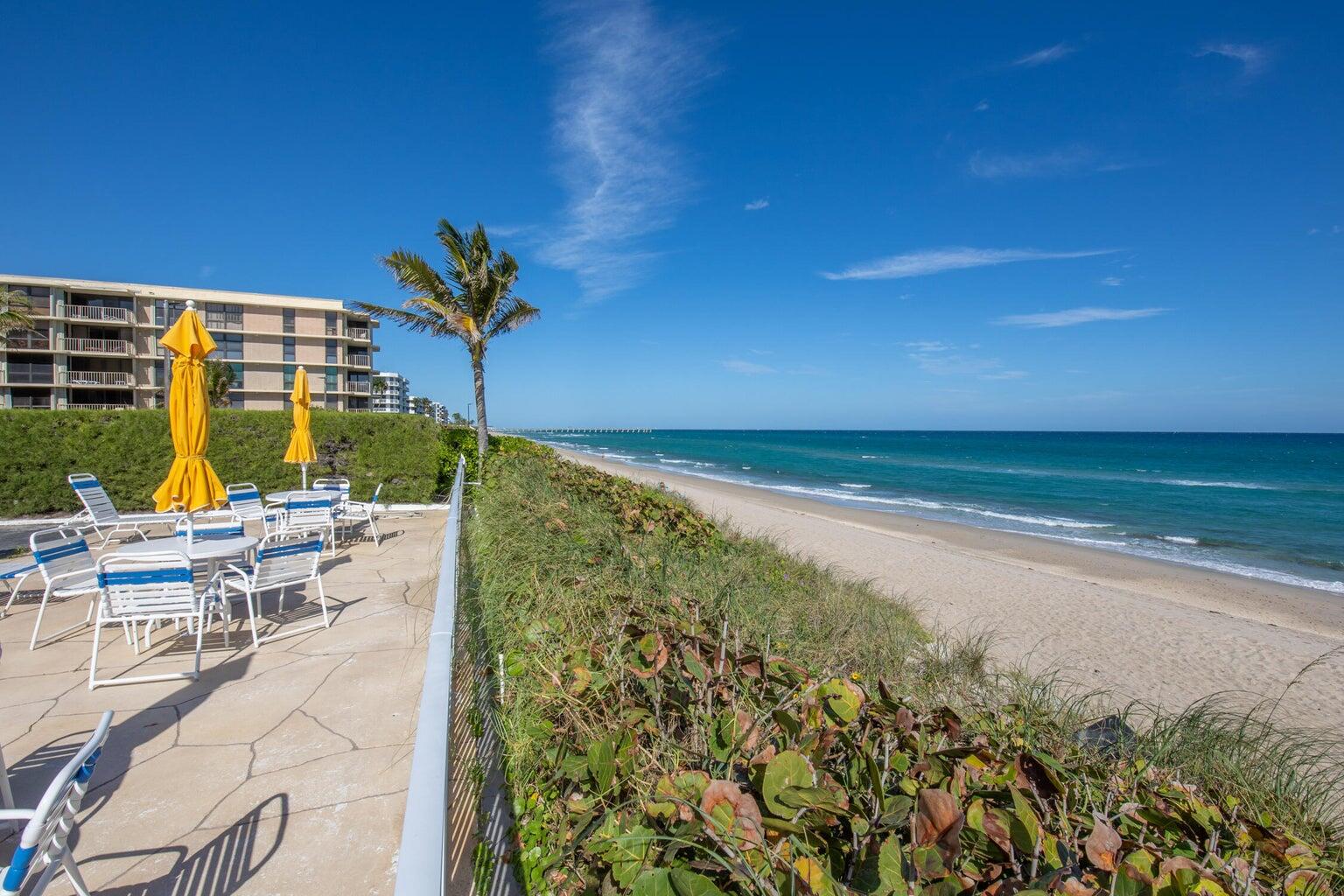 a view of an ocean with a floor to ceiling window and an outdoor seating