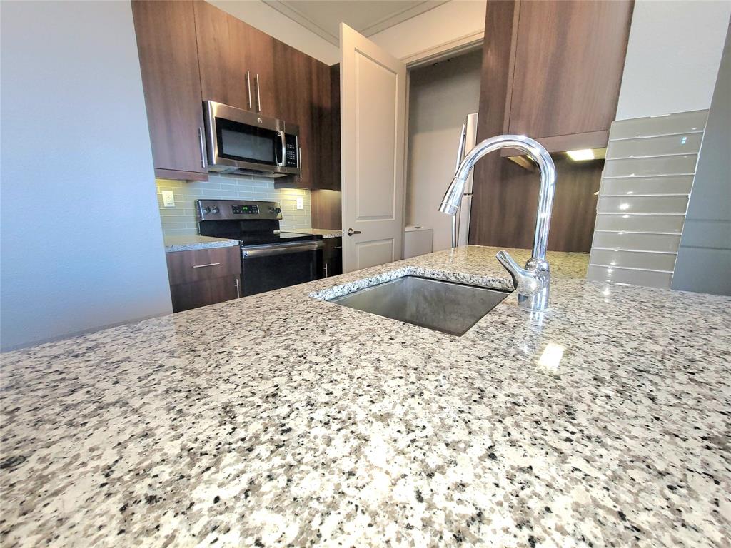 a kitchen with kitchen island sink microwave and refrigerator