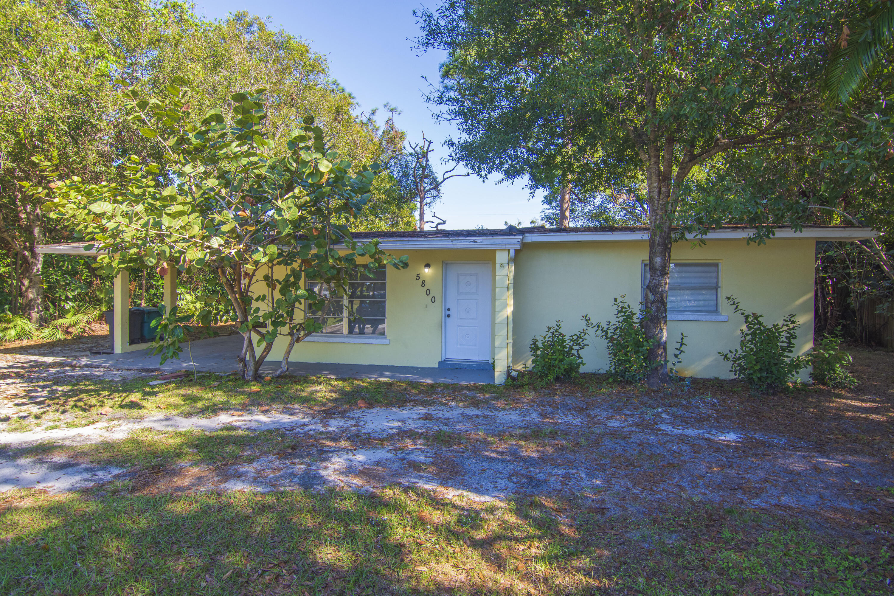 a view of a house with backyard and tree