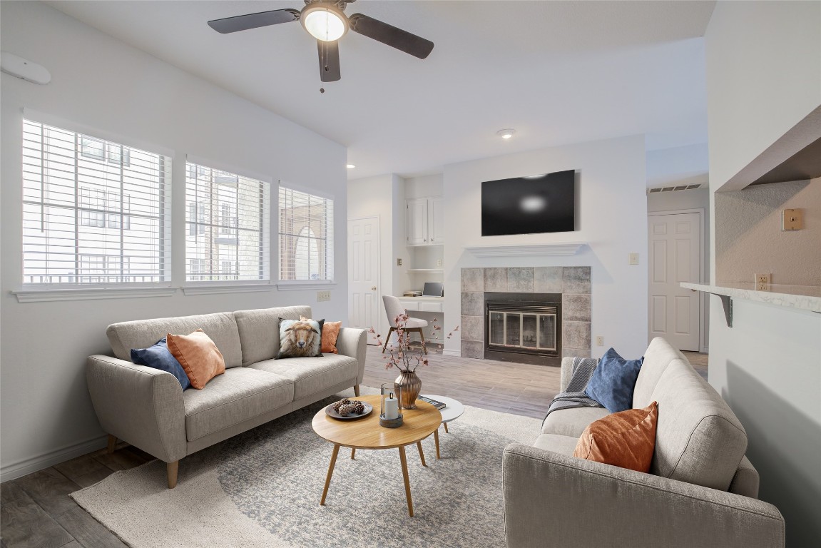 a living room with furniture a flat screen tv and a fireplace