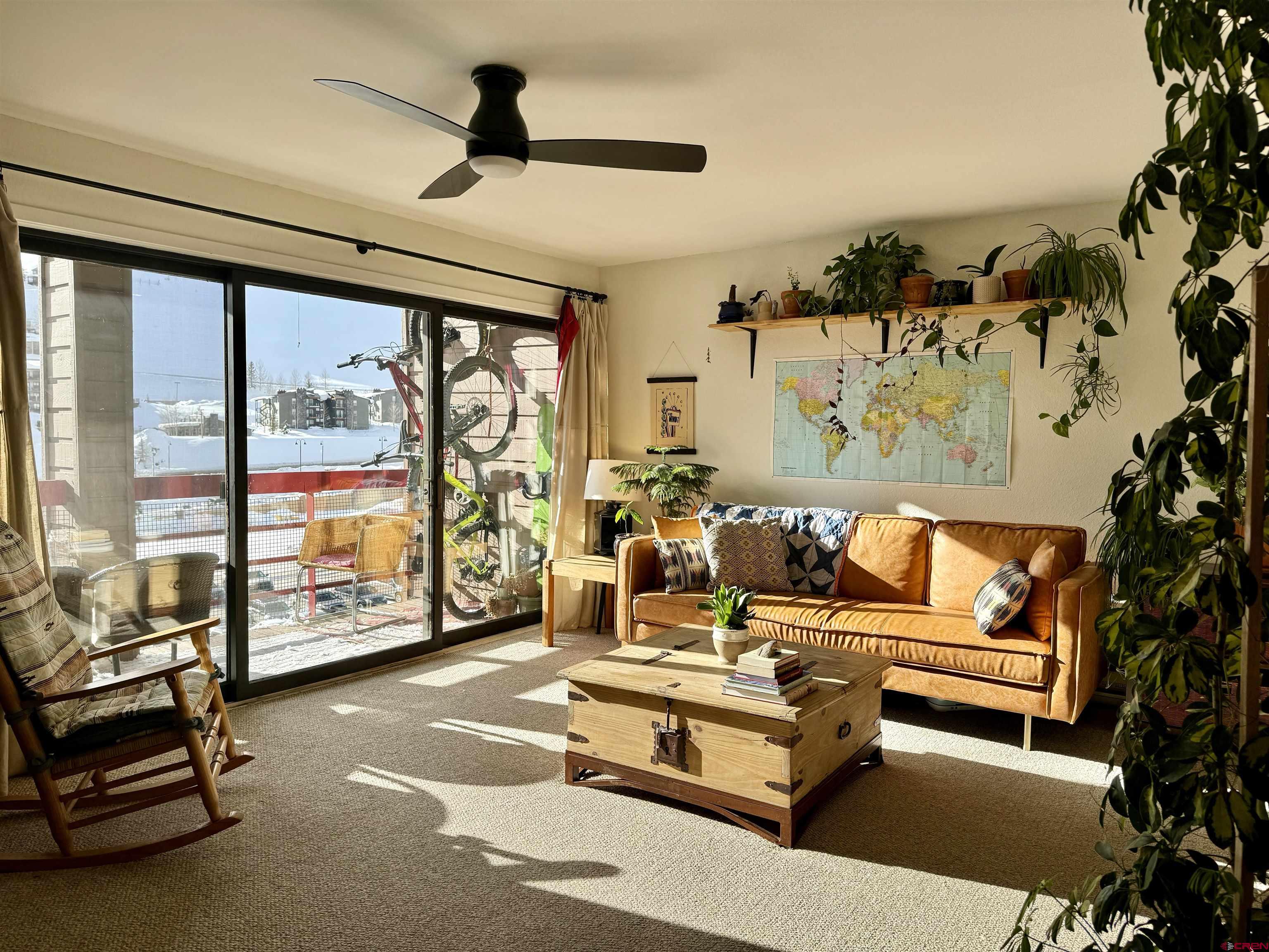 a living room with furniture and a floor to ceiling window