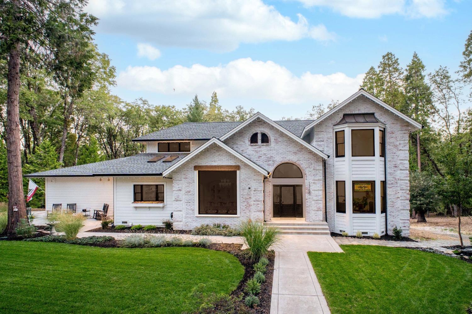 a front view of a house with a garden and yard