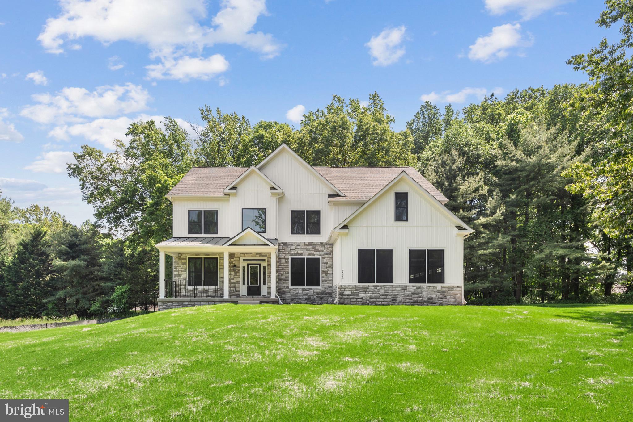 a view of a white house with a big yard and large trees