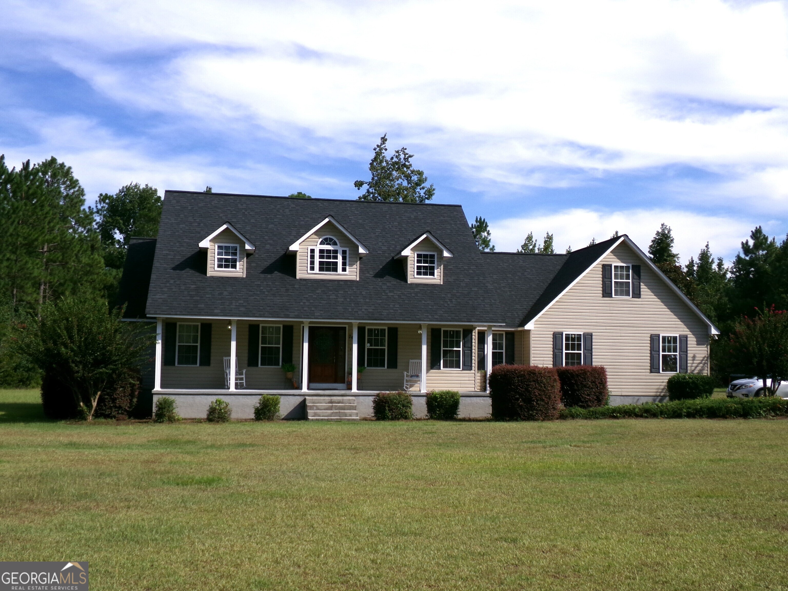 a front view of a house with a garden