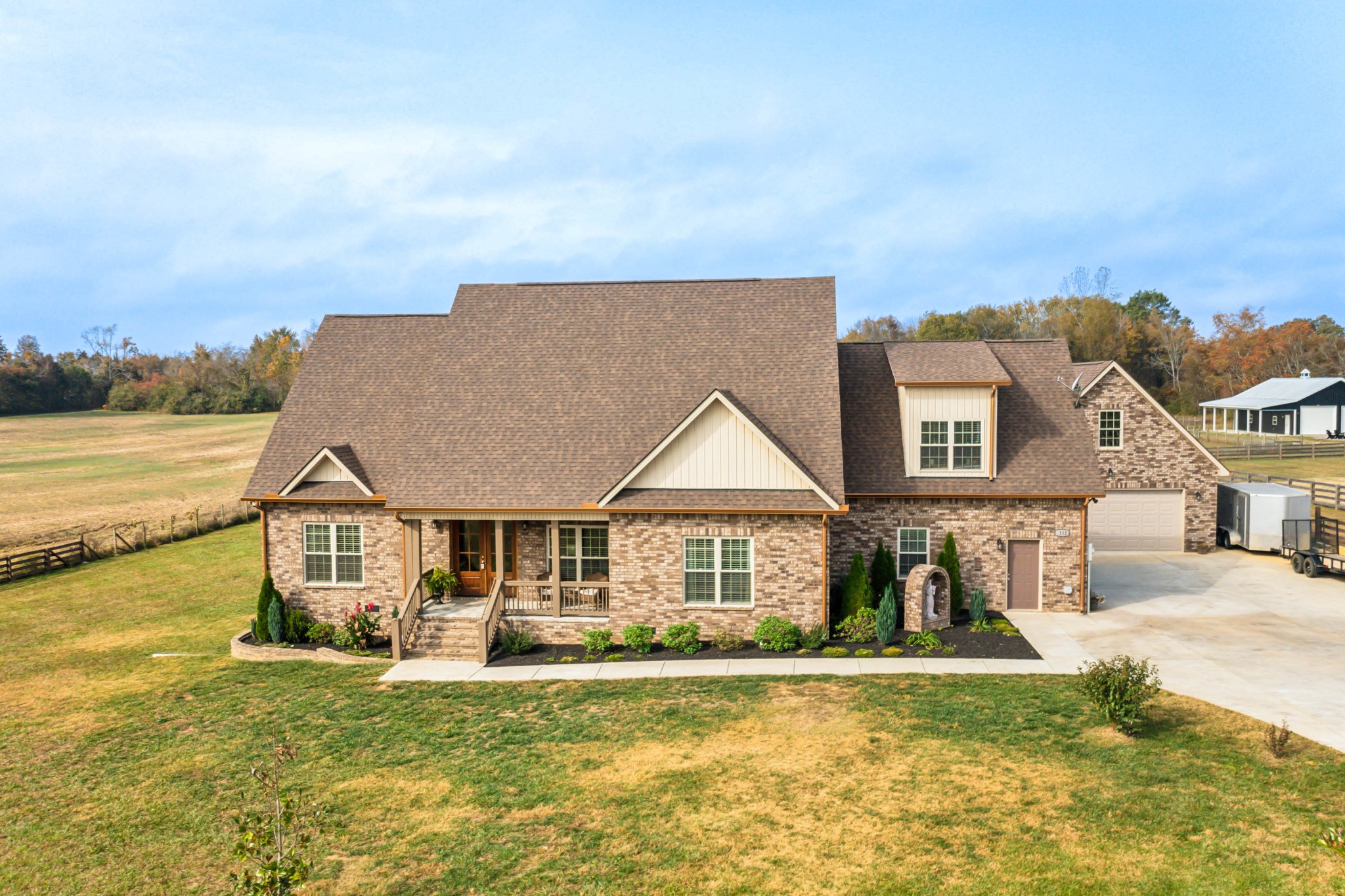 a front view of a house with a garden and lake view