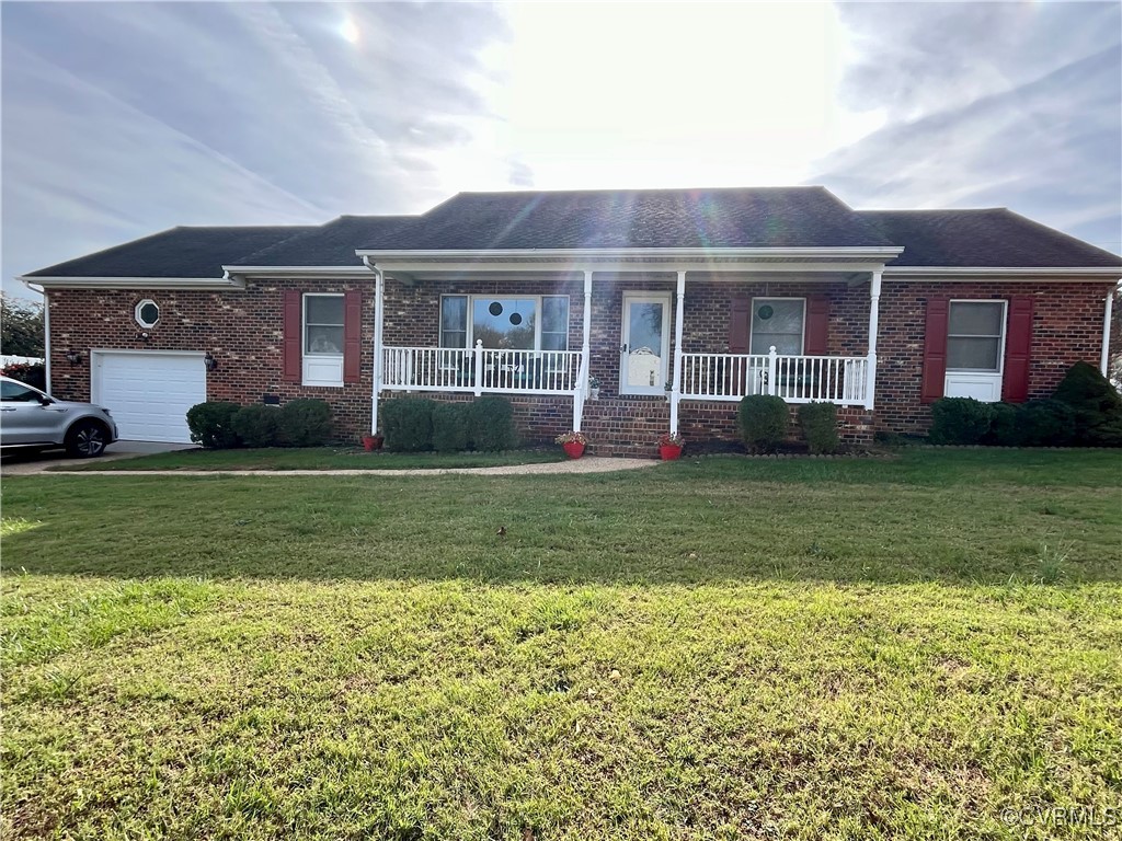 Ranch-style house featuring a front yard, a porch,