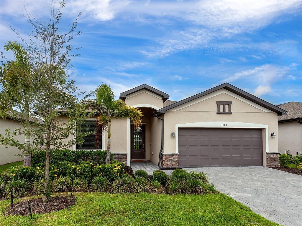 a front view of a house with a yard and garage