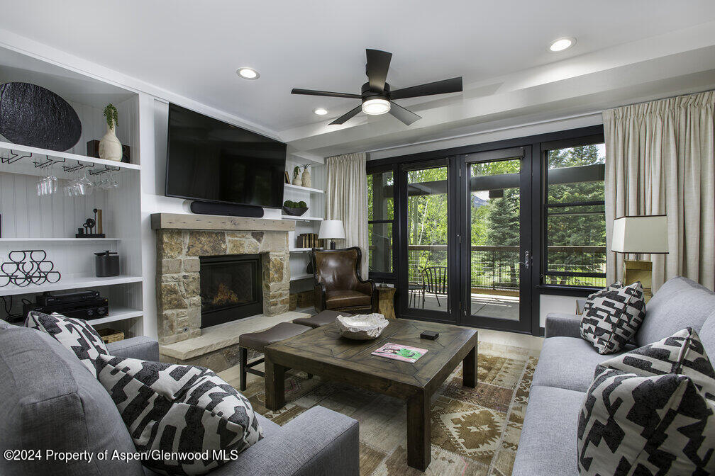 a living room with furniture a flat screen tv and a fireplace