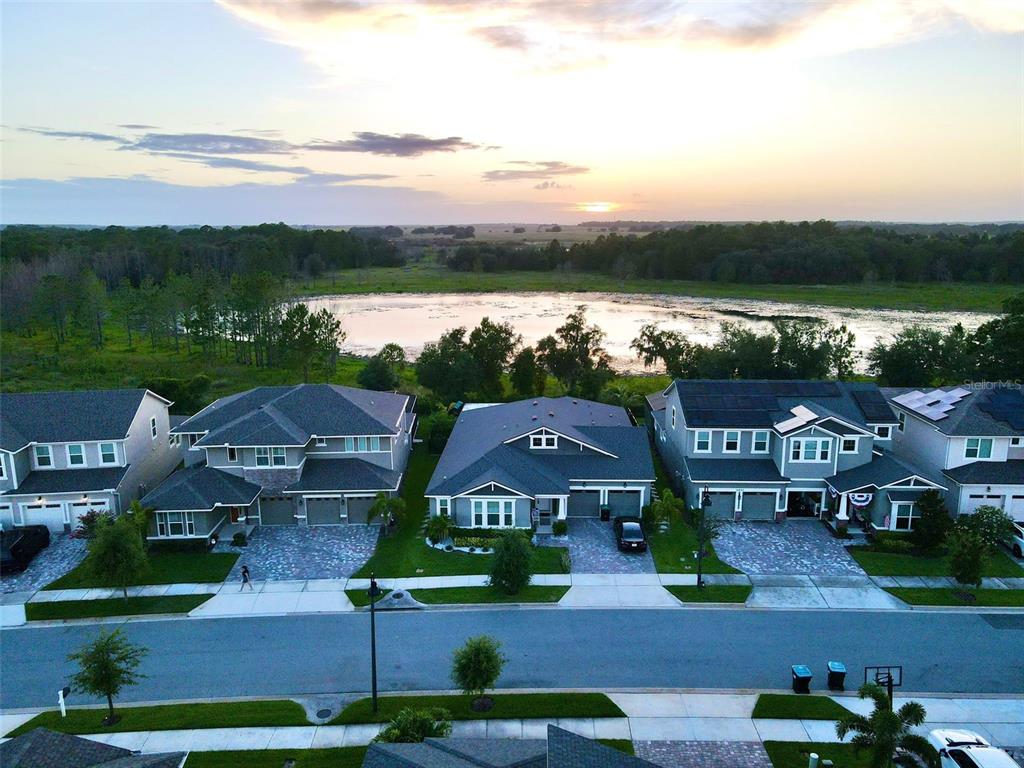 an aerial view of residential houses with outdoor space and ocean view